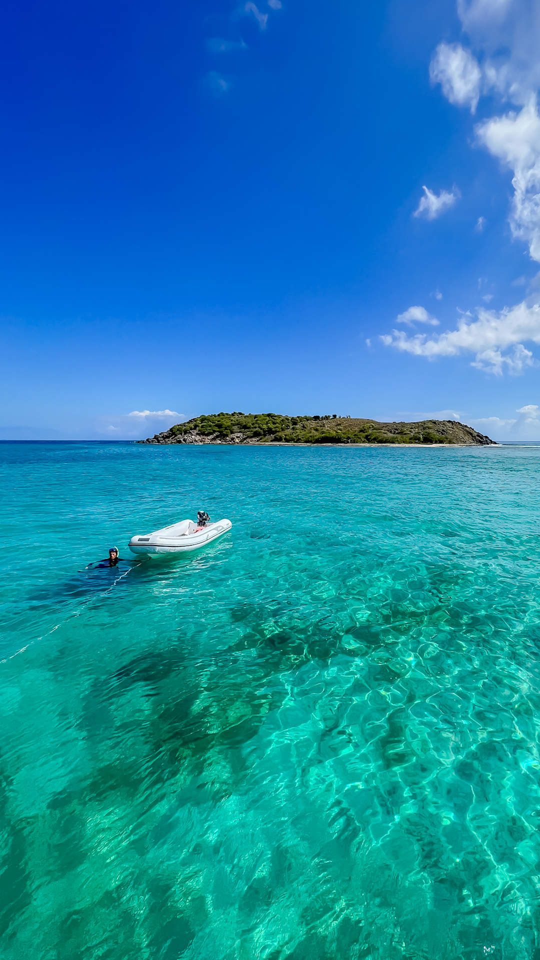 boat floating in clear ocean water in the caribbean